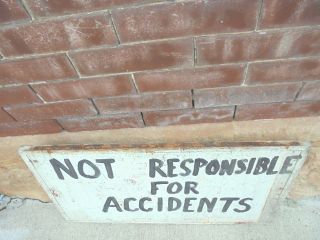 weathered wooden sign not responsible for accidents 27 