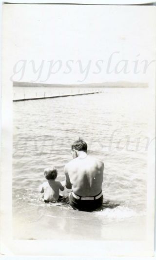 1940s Orig Photo Back Of Faceless Man & Boy In Swimsuits Sitting In Surf By Pier