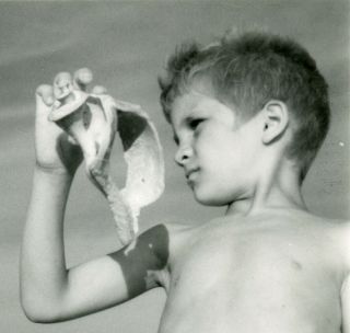 VINTAGE PHOTO - BOY HOLDING UP A SEA SHELL AT REHOBETH BEACH IN HIS SWIM TRUNKS 2