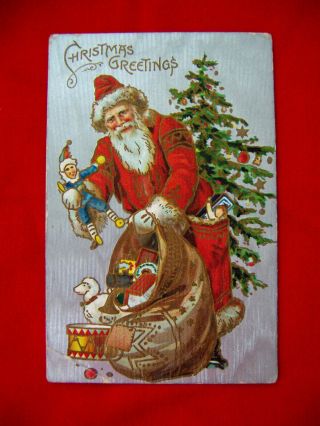 Antique1908 Embossed Red - Suit Santa Postcard - Tree,  Toy Bag,  " Christmas Greetings "