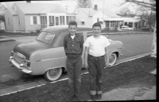 Two Young Boys Standing In Front Of Tiny Car 1950 