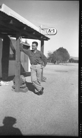 Man Leaning Against Post With A - 1 Pilsner Beer Sign Over Head 1950 