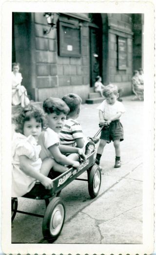 Vintage B/w Photo Of A Little Boy Pulling His Radio Flyer With Friends In Tow.