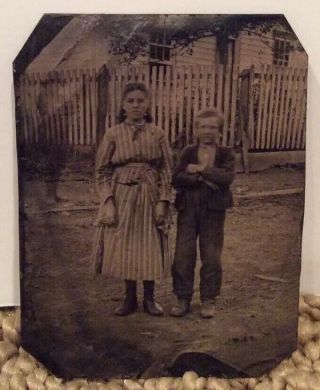 Tintype Of Girl And Boy Standing In Front Of House With Tall Fence And Ghost