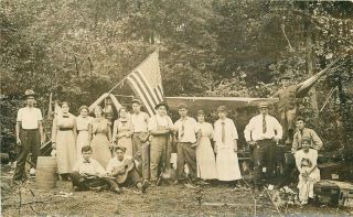 C - 1905 Group Photo Camping Patriotic Flag Guitar Shot Guns Rppc Postcard 3166