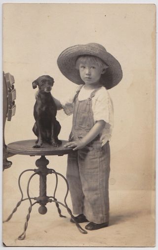 Vintage Real Photo Postcard,  Boy In Overalls With Small Dog On Table,  C.  1910.