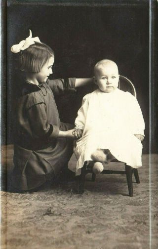 Sweet Older Sister Helping Baby Brother Pose For Picture In Little Chair - Rppc