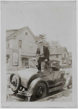 Old Photo Man Sitting On Car Roof Clothing Store Across Street 1920s