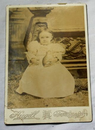 Cabinet Photo Of A Child Holding A Toy Cat