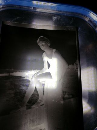 1920s Photographic Negative Girl In Bathing Suit Sitting On Seaside Breakwater