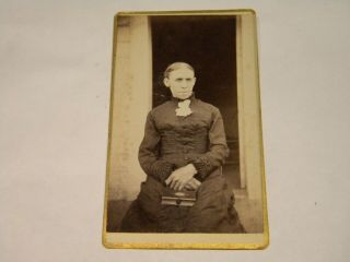A Cdv Of A Sourpuss Victorian Woman With A Long Dress And Book On Her Lap