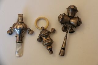 Three Antique Whistles Rattles Mainly Silver And One With Mother Of Pearl Handle