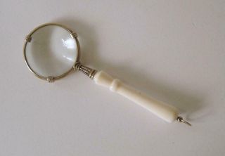 A Small Modern Sterling Silver Magnifying Glass With White Plastic Handle