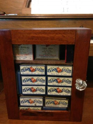 Antique Bell Brand Strings And Boxes In Wood Display Case.