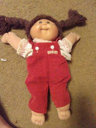 Vintage 1984 Cabbage Patch Doll W/ Dark Brown Hair And Red Overalls.  Good Cond.