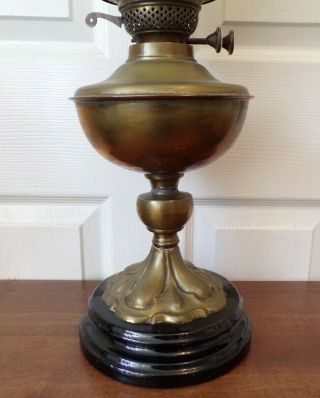 A Victorian brass oil lamp on a black glazed base with White shade order 4
