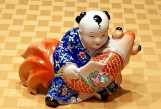 Chinese Porcelain Figurine Of A Male Figure Holding A Giant Koi And Lotus Flower