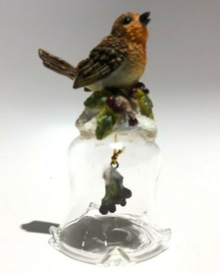 Clear Glass Dinner Bell With Colorful Bird Sitting On Top