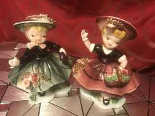 2 Vintage Napco Ceramic Figurines Girl In Green & Girl In Burgundy With Flowers