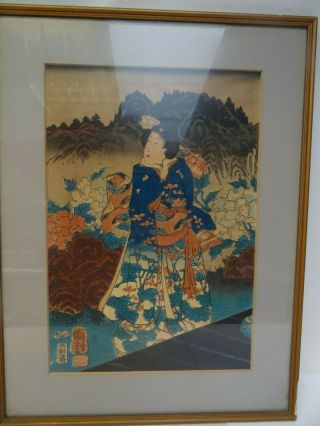 A Vintage Japanese Woodcut Print Of A Geisha Girl With Flowers And Mountains