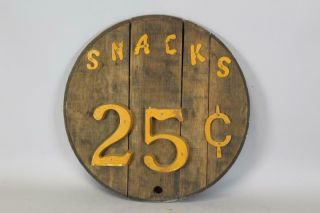 A Vintage Folk Art Sign " Snacks 25c " Made From Old Whiskey Barrel Top