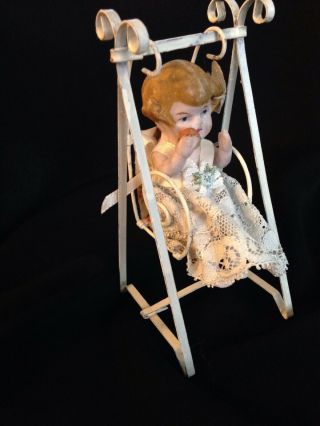Antique German Miniature Bisque Doll sitting on a swing 2