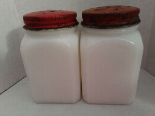 2 White Vintage Milk Glass Shakers With Red Lids.
