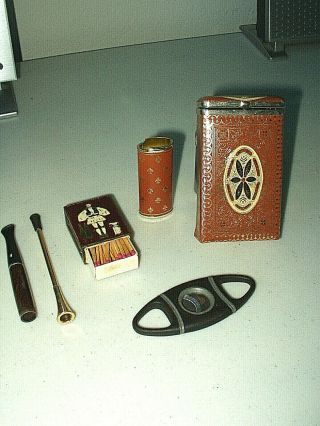 Cigarette Items: Pack Holder,  Brass Match Box,  (2) Holders,  Cigar Snip,  Etc.
