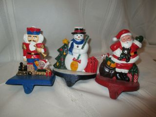 3 Vintage Cast - Iron Stocking Holders.  Nutcracker,  Snowman,  Santa Made In Taiwan