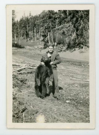 Hunter Holding Up A Dead Bear - Vintage Snapshot Black And White Photo