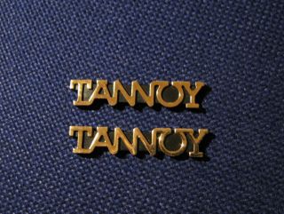 Tannoy 2 X Plastic Golden Logo Emblem Badges.  Size: 47mm X 10mm.